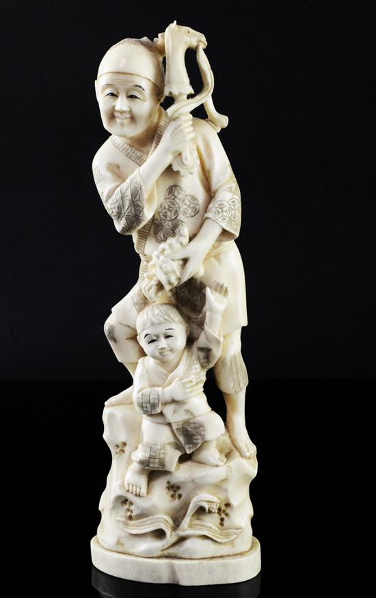 A Japanese walrus ivory okimono of a man and a boy, early 20th century, 23.5cm
